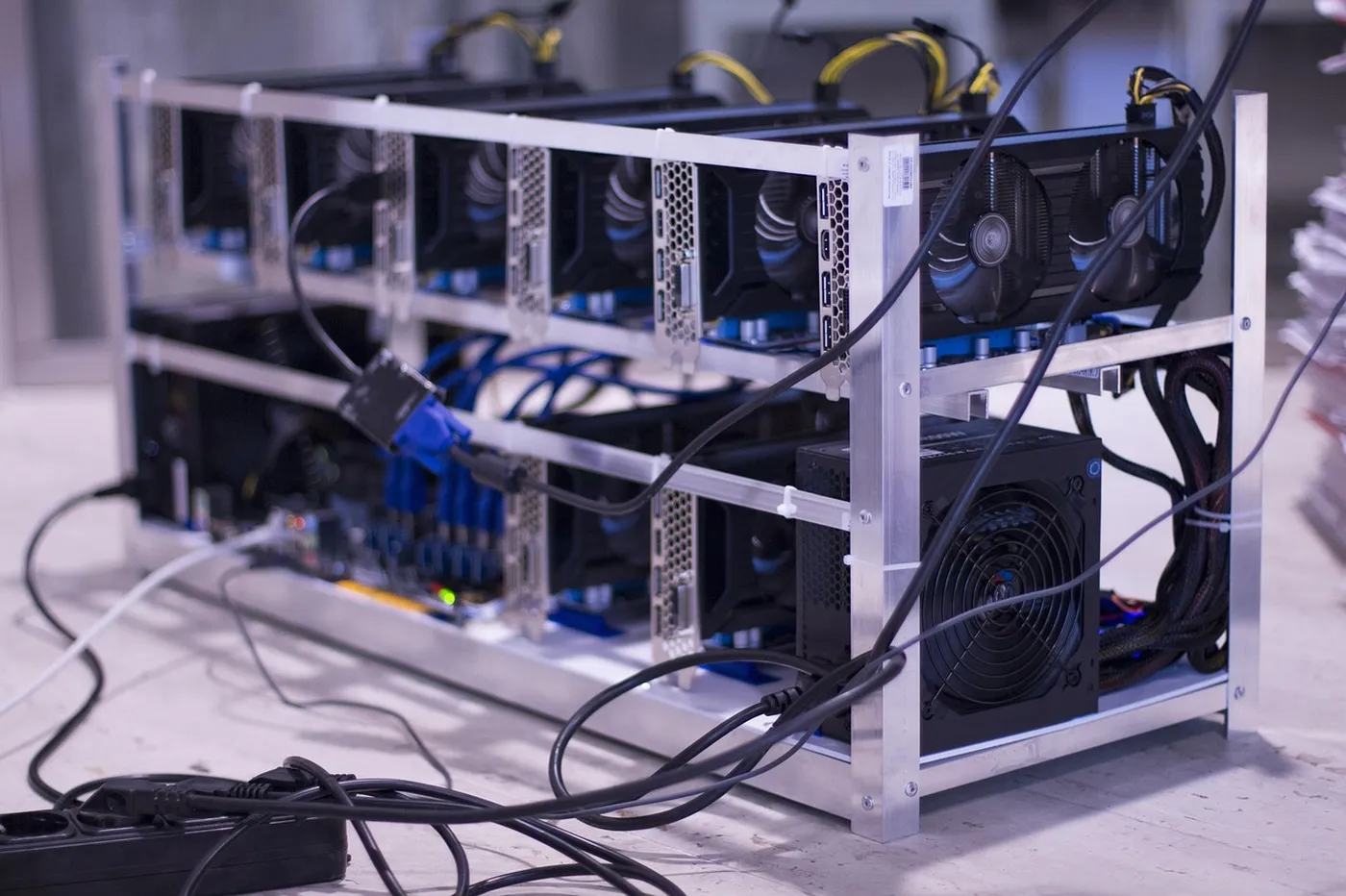 Rangées de cartes graphiques dans une ferme de minage Bitcoin, illustrant les coûts matériels de la production de cryptomonnaies
