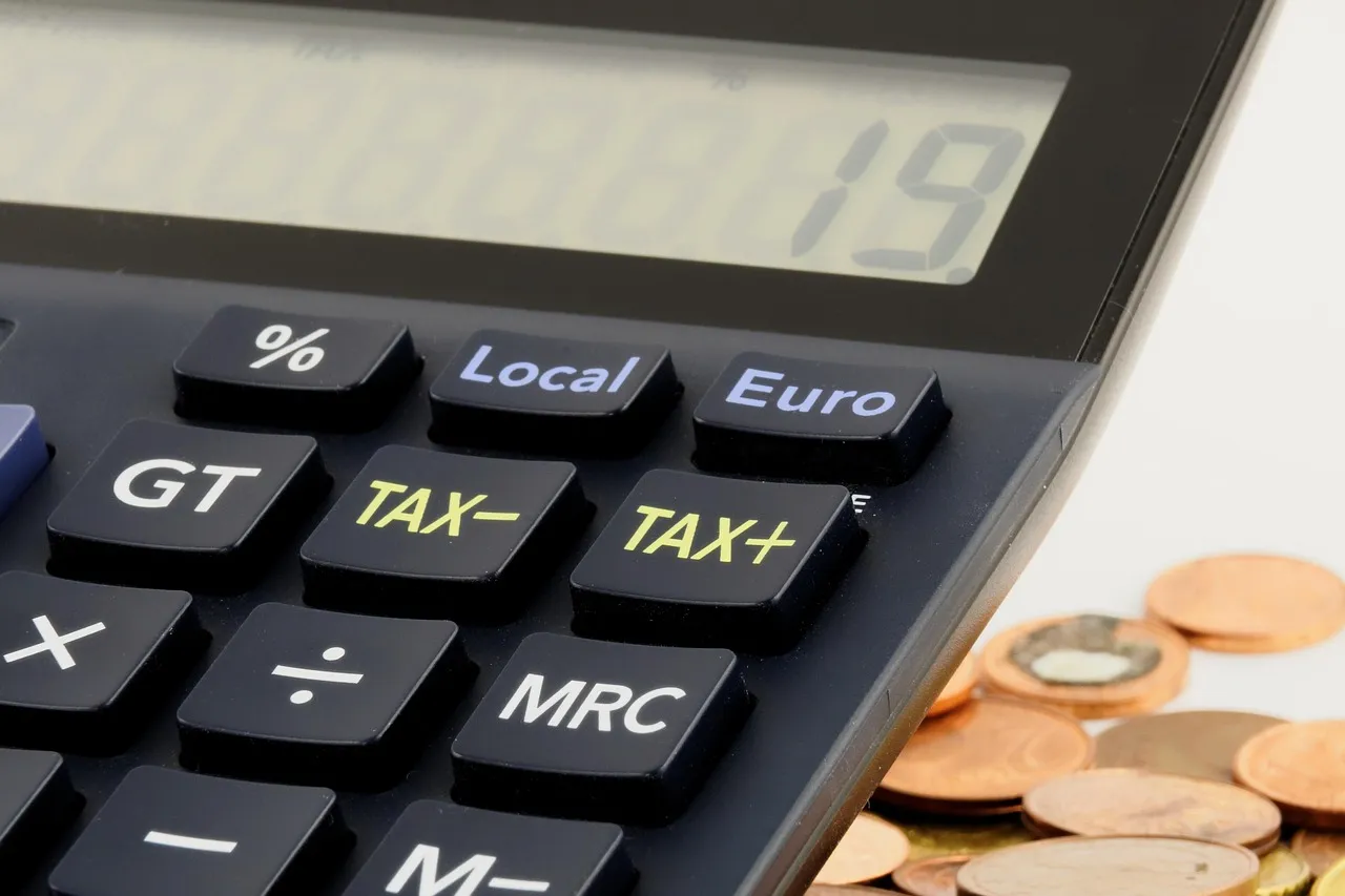 Calculatrice et pièces en euros illustrant la hausse de la flat tax à 31,4 % en 2026