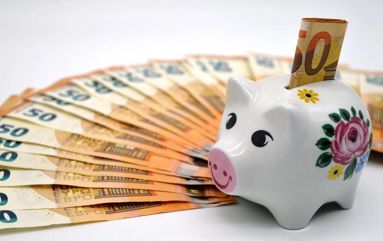 Tirelire cochon entourée de billets en euros, symbolisant l'épargne face à l'inflation en zone euro en 2026